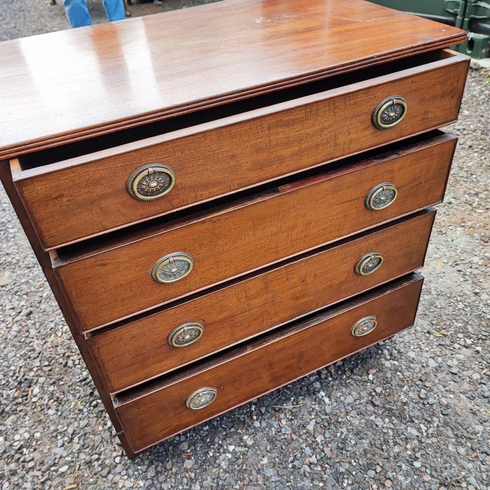 An antique Regency mahogany chest of drawers featuring four full-width drawers with brass oval handles and bracket feet. View III