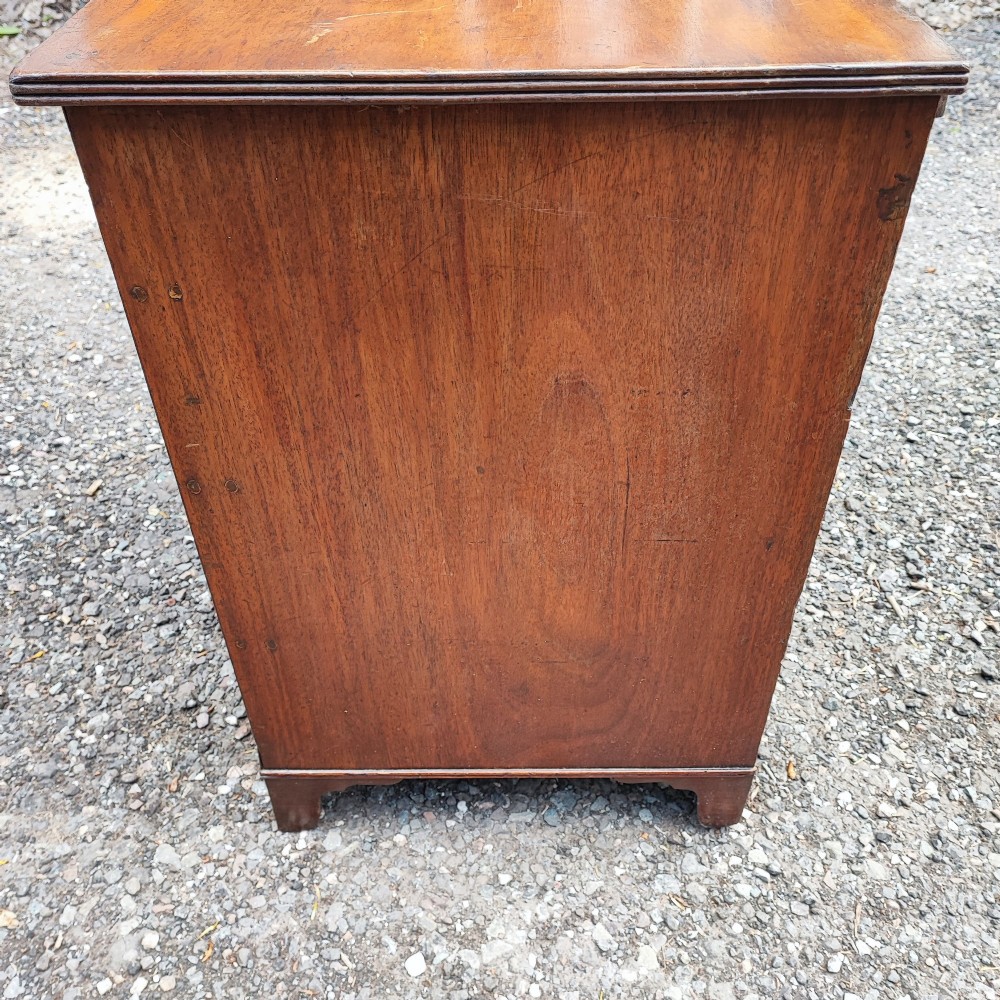 An antique Regency mahogany chest of drawers featuring four full-width drawers with brass oval handles and bracket feet. View IV