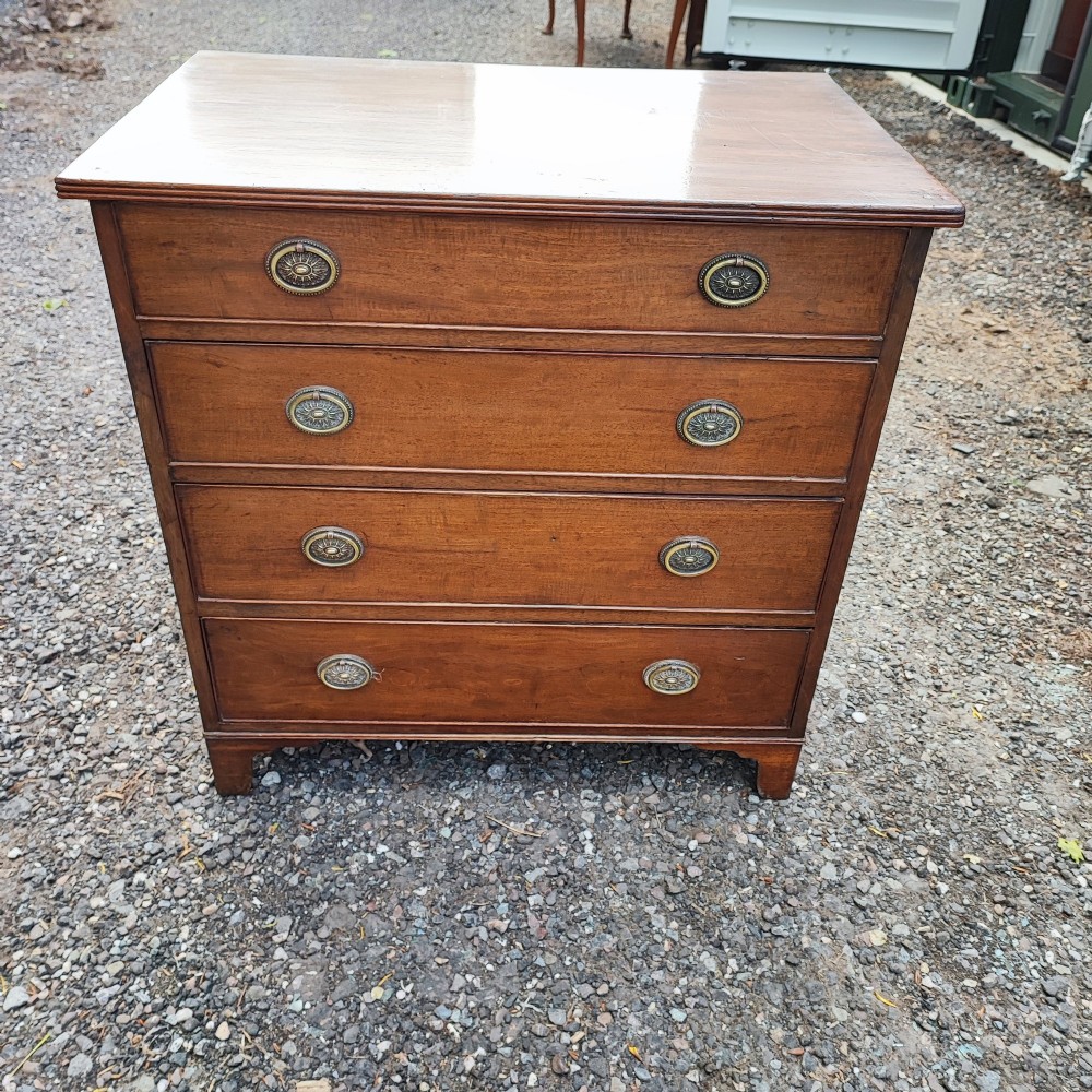 An antique Regency mahogany chest of drawers featuring four full-width drawers with brass oval handles and bracket feet. View VI