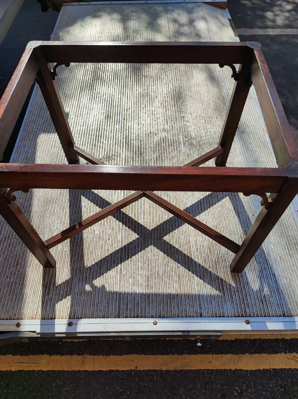An antique mahogany campaign tray table featuring four hinged drop-down gallery sides with cutout carry handles and brass fittings, supported on a matching wooden stand. View IV