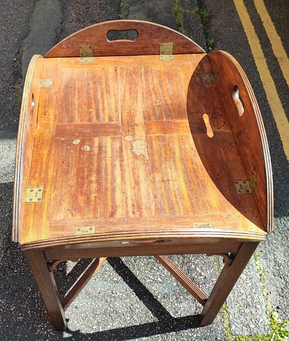 An antique mahogany campaign tray table featuring four hinged drop-down gallery sides with cutout carry handles and brass fittings, supported on a matching wooden stand. View VI