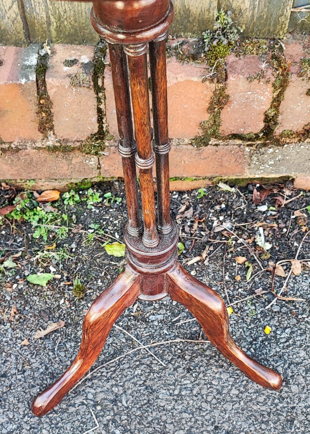An antique mahogany wine table featuring a dished circular top, a turned cluster column stem, and three curved tripod legs. View II