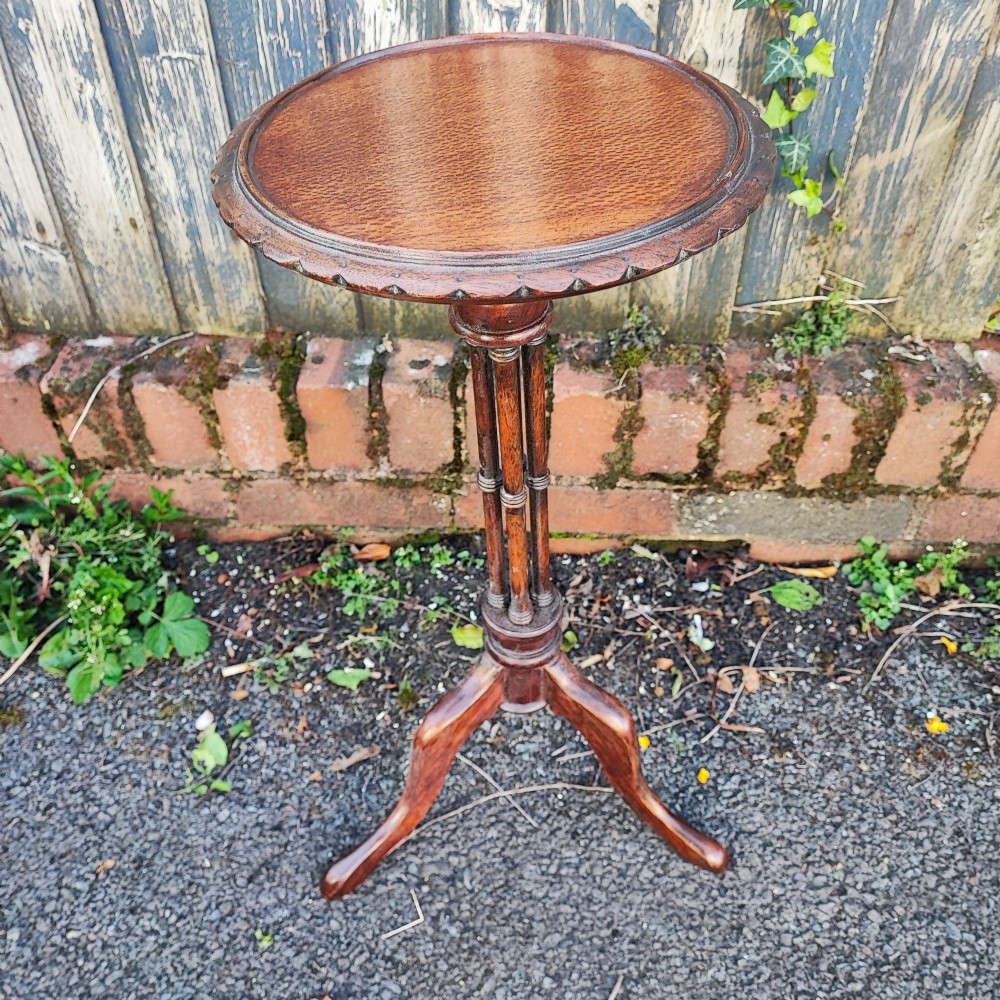 An antique mahogany wine table featuring a dished circular top, a turned cluster column stem, and three curved tripod legs. View IV