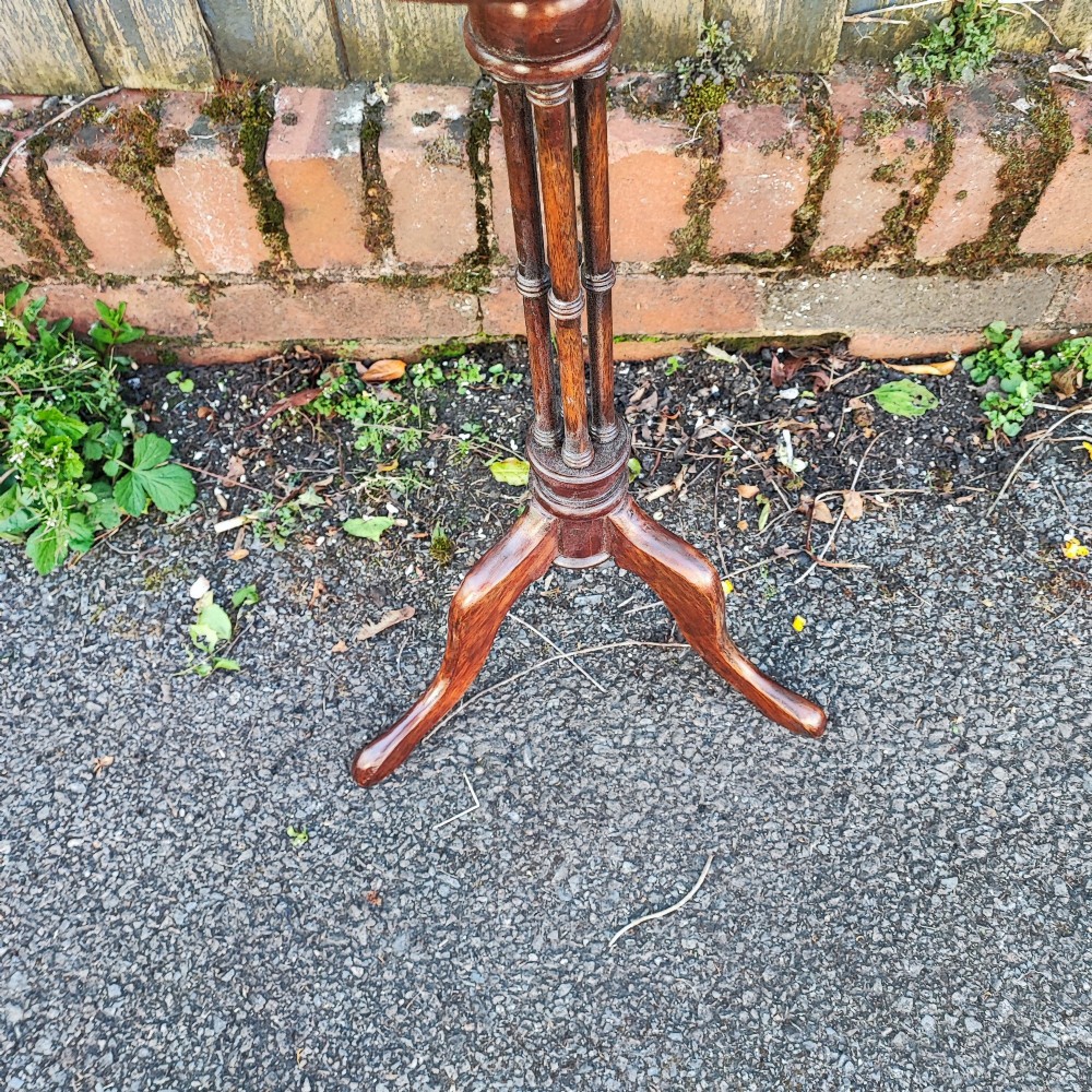 An antique mahogany wine table featuring a dished circular top, a turned cluster column stem, and three curved tripod legs. View V