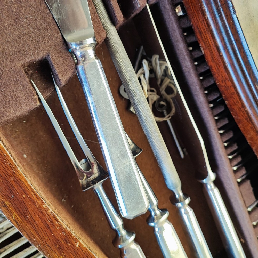 An open burr walnut cutlery canteen table featuring two fitted drawers containing rows of silver-plated flatware. View VI