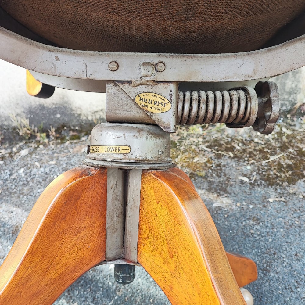 An antique mahogany revolving desk chair featuring a curved slatted back, studded leather seat, and a quadruped swivel base on castors. View IX