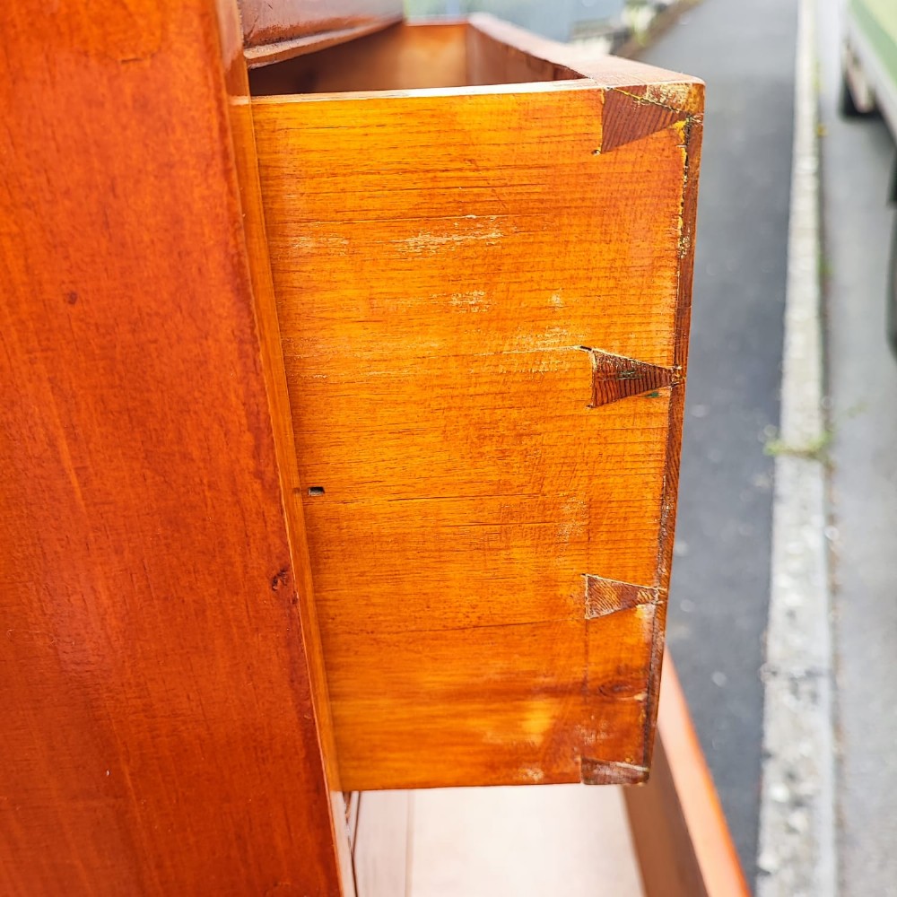 A tall antique pine chest of drawers featuring eight drawers with brass drop handles and a natural honey wood grain. View IV