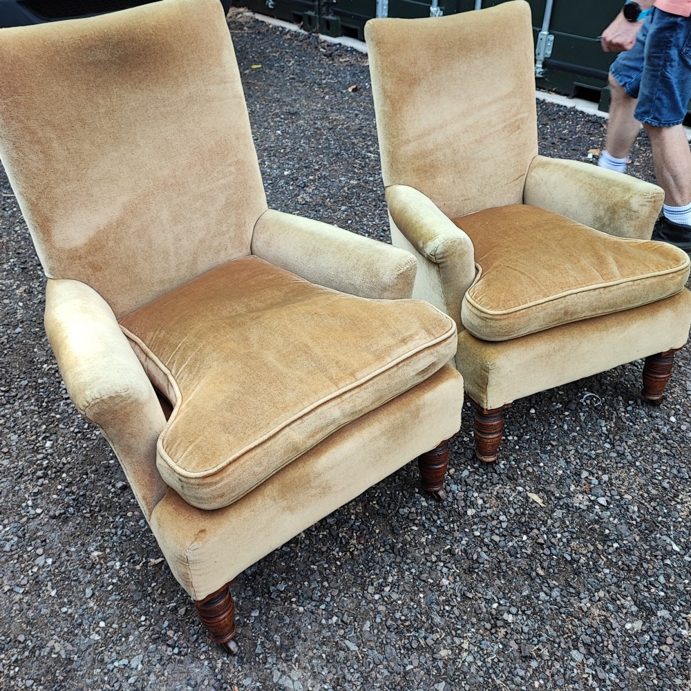 A pair of Victorian armchairs upholstered in gold velvet fabric featuring high backrests and turned walnut front legs on brass castors. View II