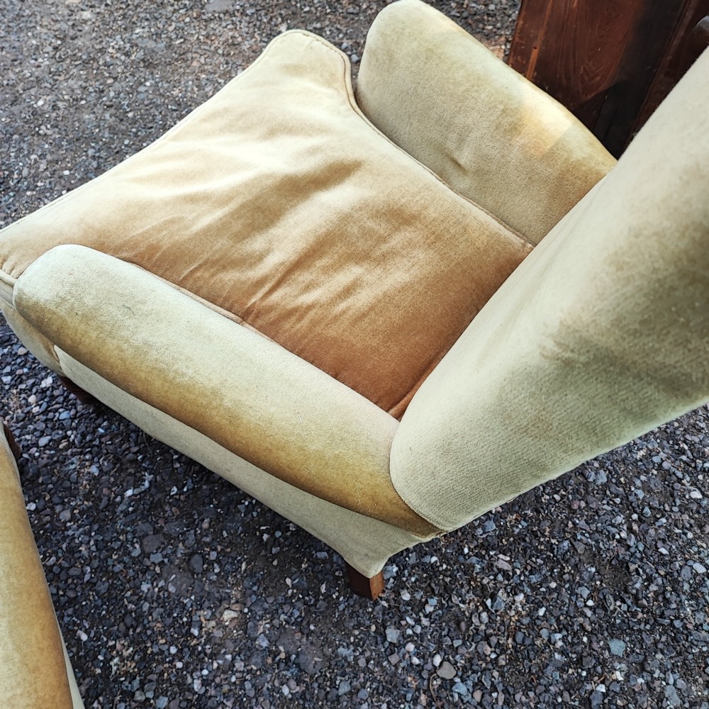 A pair of Victorian armchairs upholstered in gold velvet fabric featuring high backrests and turned walnut front legs on brass castors. View V