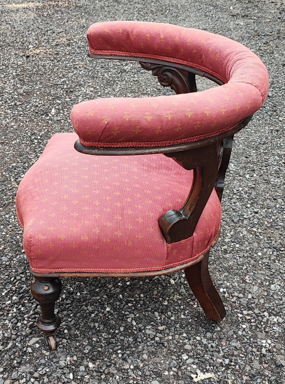 A Victorian mahogany desk chair featuring a padded red horseshoe backrest, carved central splat, and turned legs with castors. View VII