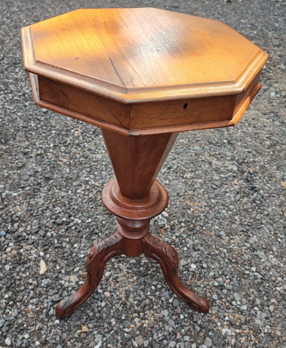 A Victorian walnut trumpet work box featuring an octagonal hinged top, tapering conical body, and carved tripod cabriole legs. View III