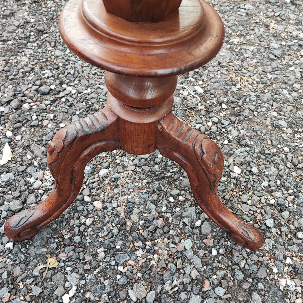 A Victorian walnut trumpet work box featuring an octagonal hinged top, tapering conical body, and carved tripod cabriole legs. View VI