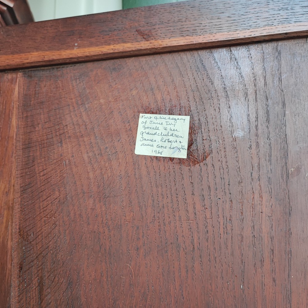 An antique brown oak hanging corner cupboard featuring a central sunburst inlaid door panel, chequered border stringing, and decorative brass hinges. View VIII
