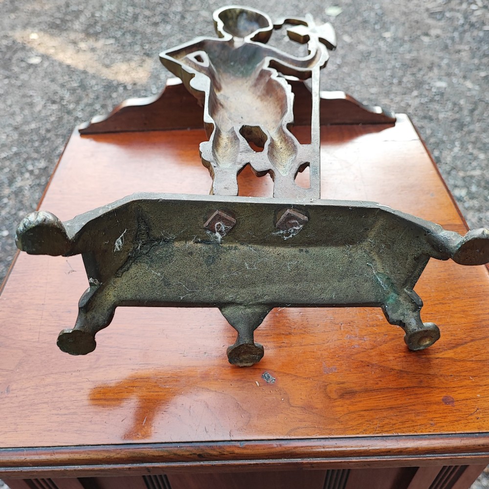 An antique cast brass doorstop depicting a Scottish Highlander soldier holding a halberd, set upon a stepped base with claw feet. View VI