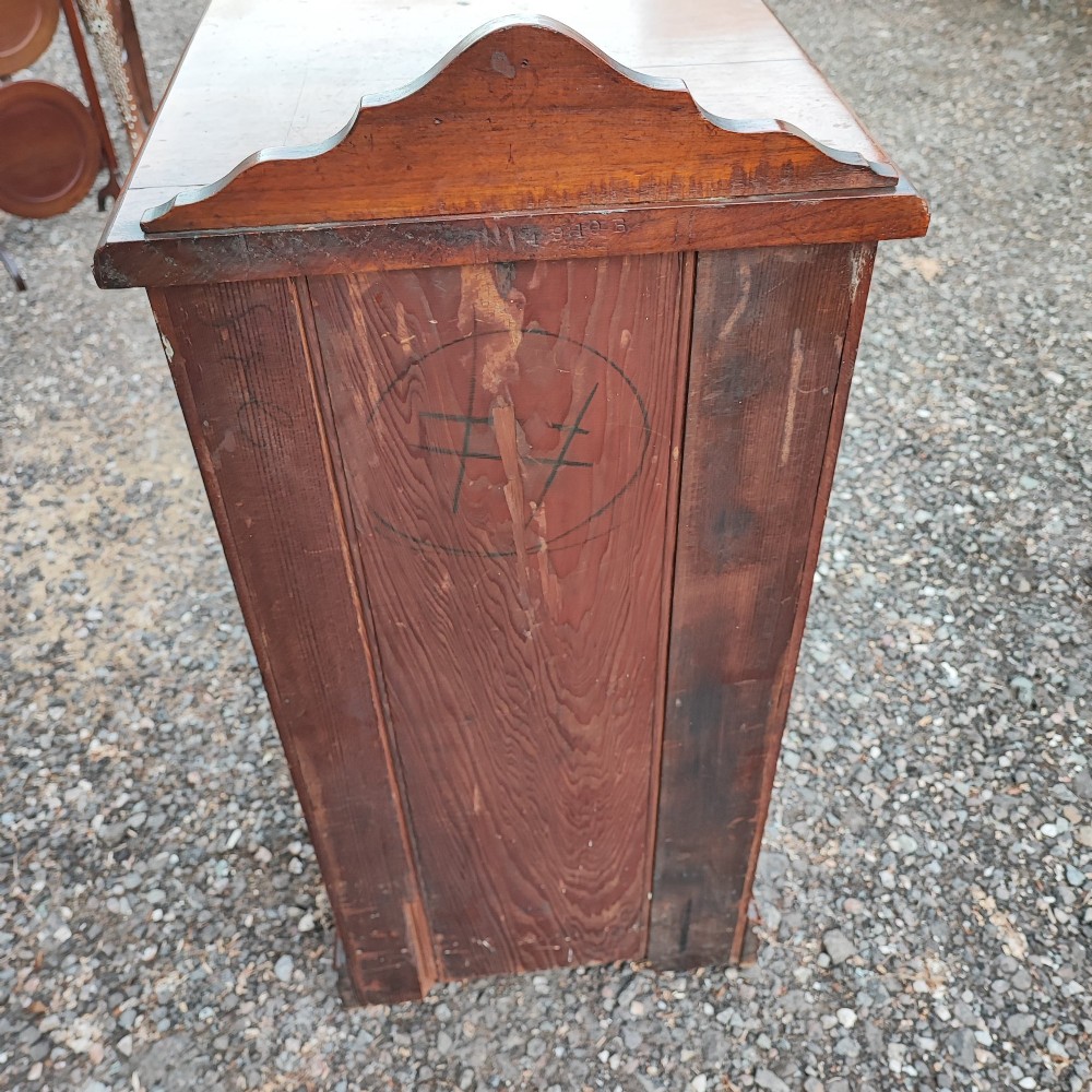 An Edwardian mahogany bedside cabinet with a shaped splashback, reeded door moulding, and a single brass drop handle. View VI