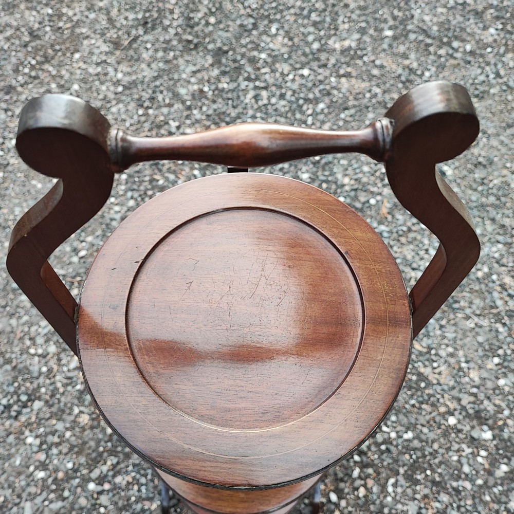 An Edwardian three-tier mahogany cake stand with boxwood string inlay, circular trays, and a arched top carrying handle. View III