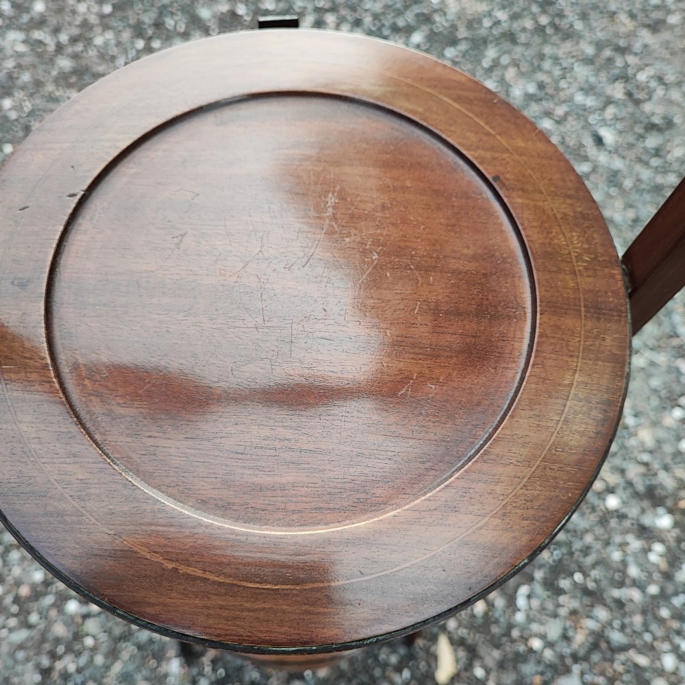 An Edwardian three-tier mahogany cake stand with boxwood string inlay, circular trays, and a arched top carrying handle. View IV