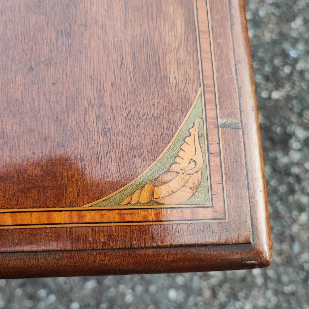 An Edwardian mahogany chest of four drawers featuring boxwood stringing inlay, crossbanded top, circular brass ring handles, and bracket feet. View II