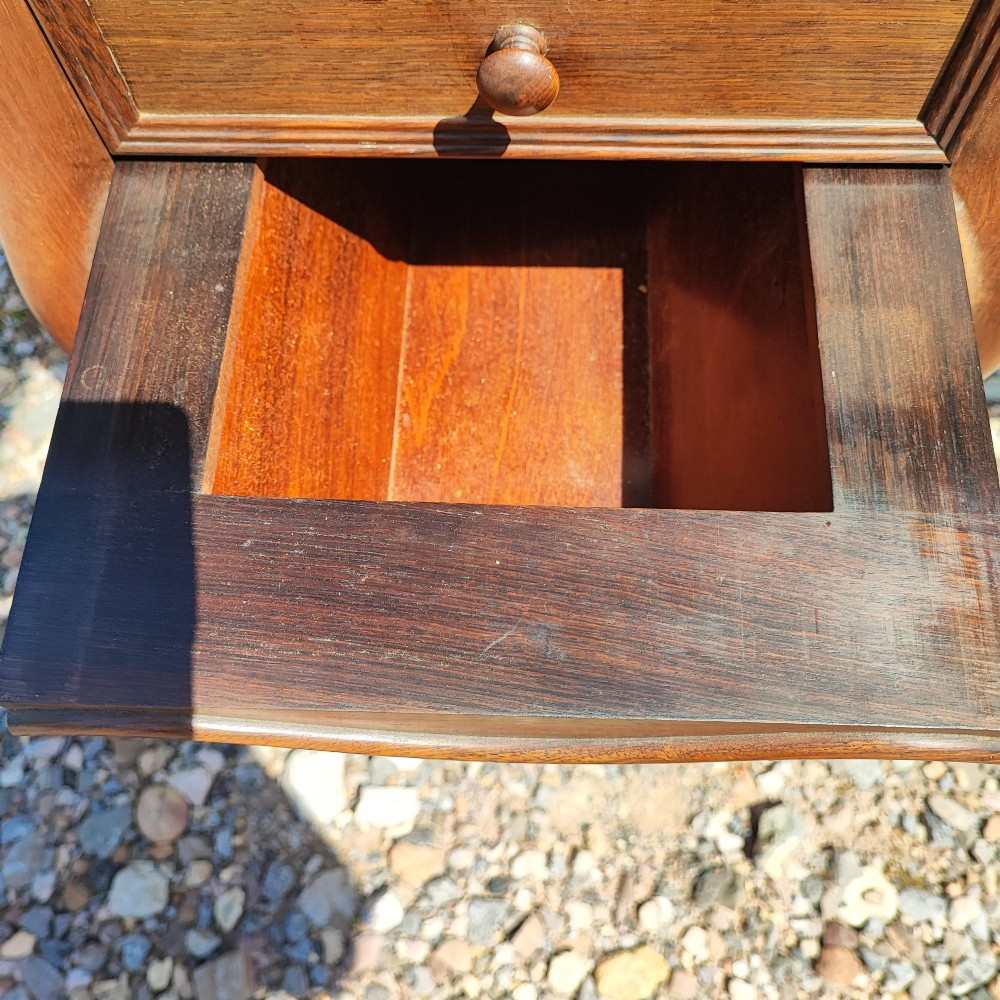 An antique rosewood drop leaf bedside table featuring cabriole legs and two front drawers with small wooden knobs. View V