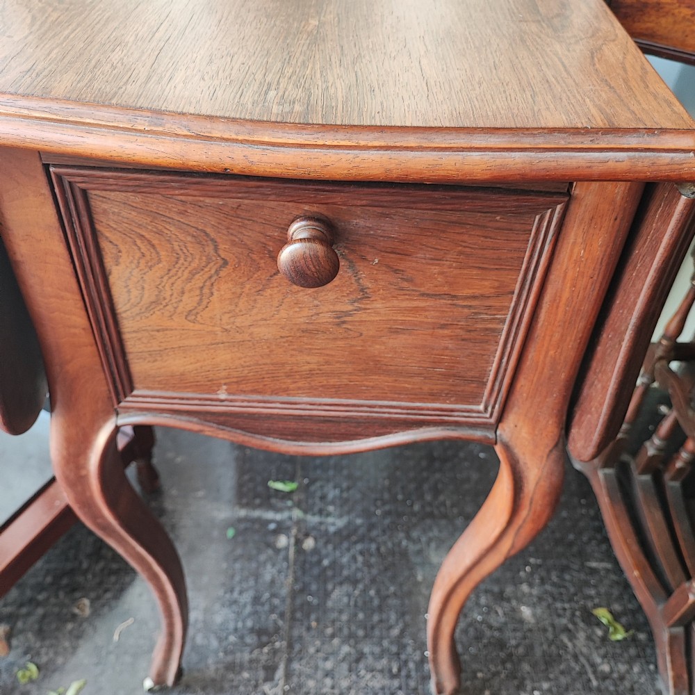 An antique rosewood drop leaf bedside table featuring cabriole legs and two front drawers with small wooden knobs. View IX