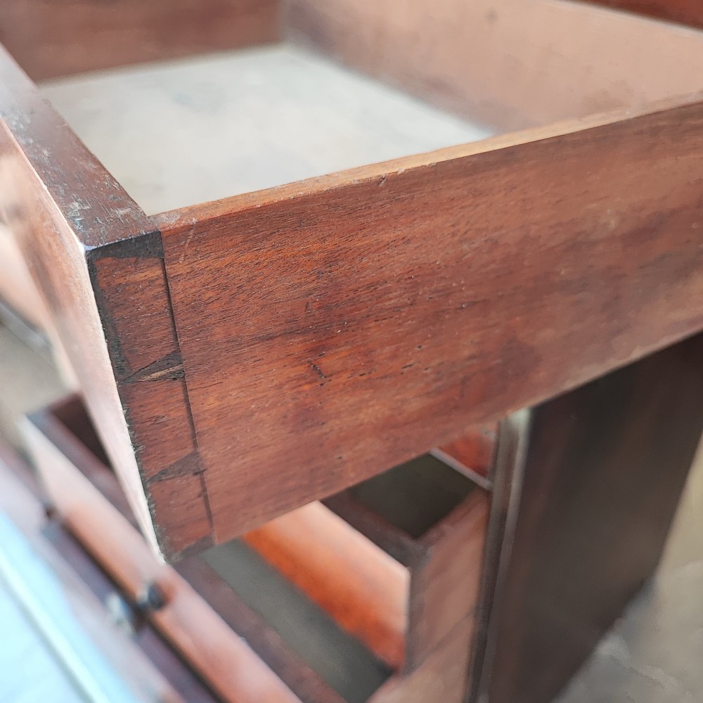 A Regency mahogany watchmaker chest featuring a top hinged compartment above multiple small drawers with turned wooden handles. View IV