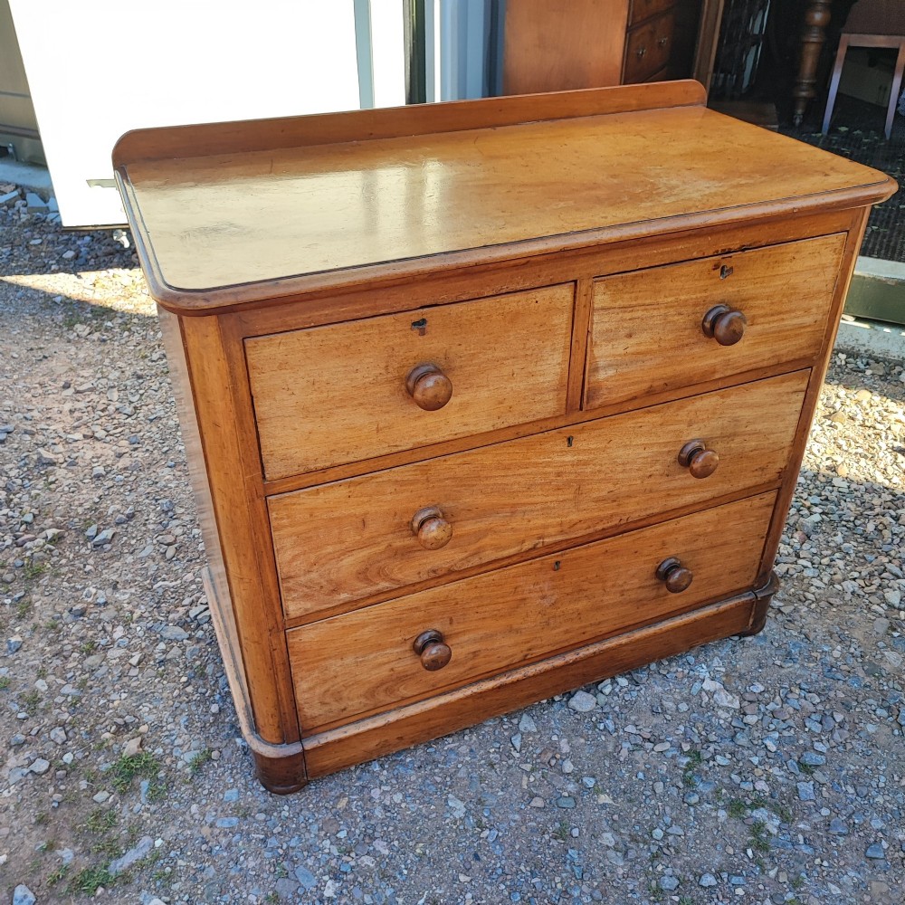 A Victorian mahogany chest featuring two short drawers above two long drawers, fitted with turned wooden knobs and a low rear upstand.