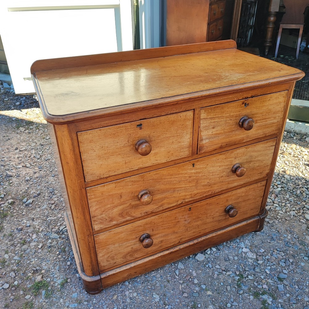 A Victorian mahogany chest featuring two short drawers above two long drawers, fitted with turned wooden knobs and a low rear upstand. View II