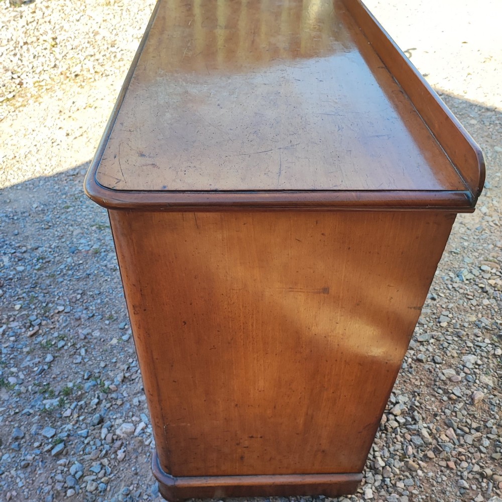 A Victorian mahogany chest featuring two short drawers above two long drawers, fitted with turned wooden knobs and a low rear upstand. View IV