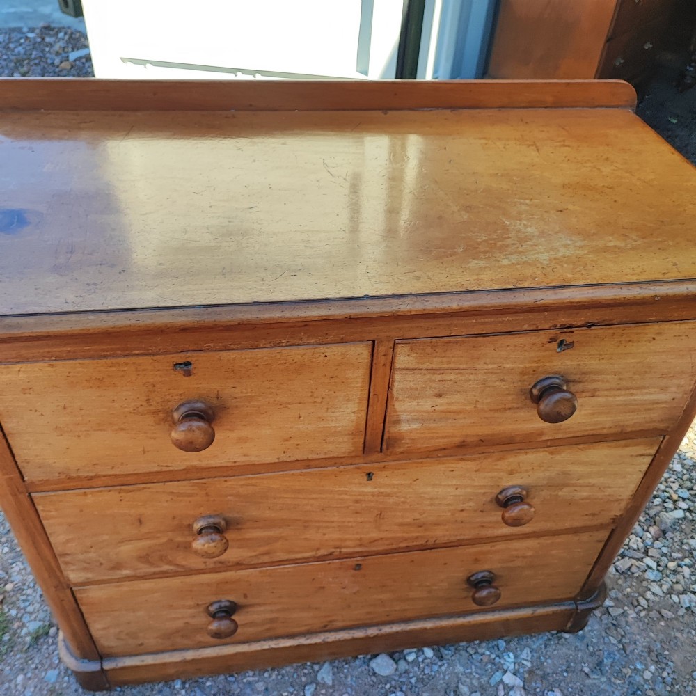 A Victorian mahogany chest featuring two short drawers above two long drawers, fitted with turned wooden knobs and a low rear upstand. View V