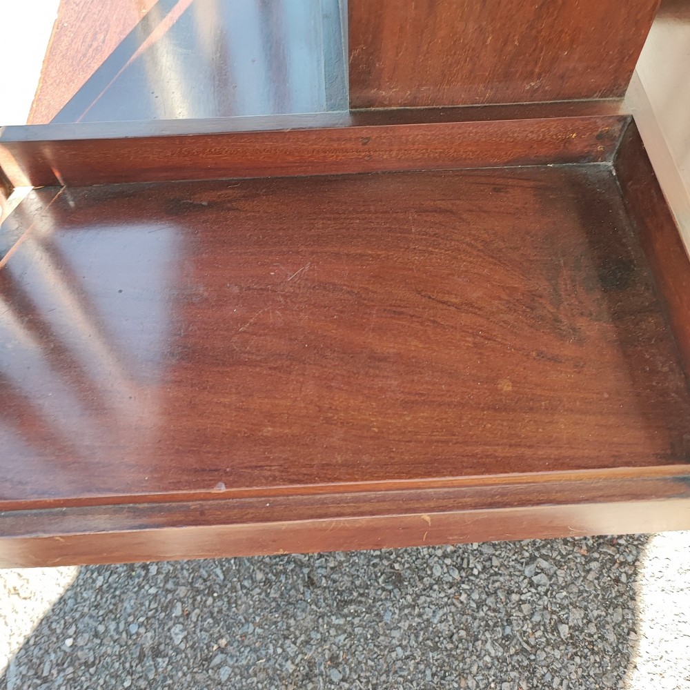 An Edwardian inlaid mahogany revolving bookcase featuring a square top with a central starburst patera inlay, three small drawers with brass ring handles, and vertical timber side slats. View VII