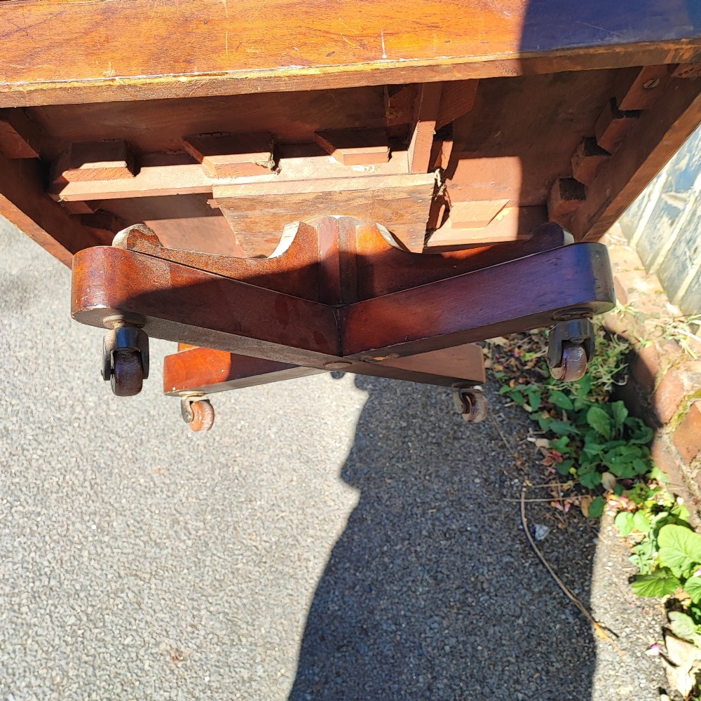 An Edwardian inlaid mahogany revolving bookcase featuring a square top with a central starburst patera inlay, three small drawers with brass ring handles, and vertical timber side slats. View VIII