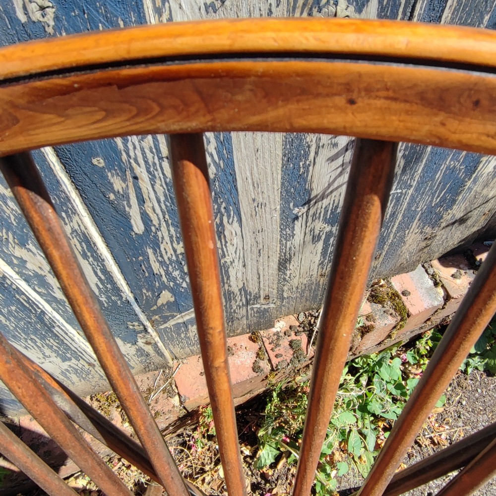 An antique wooden Windsor armchair crafted from yew and elm, featuring a hoop back with thin spindles, curved armrests, a shaped saddle seat, turned legs, and a rounded stretcher. View II