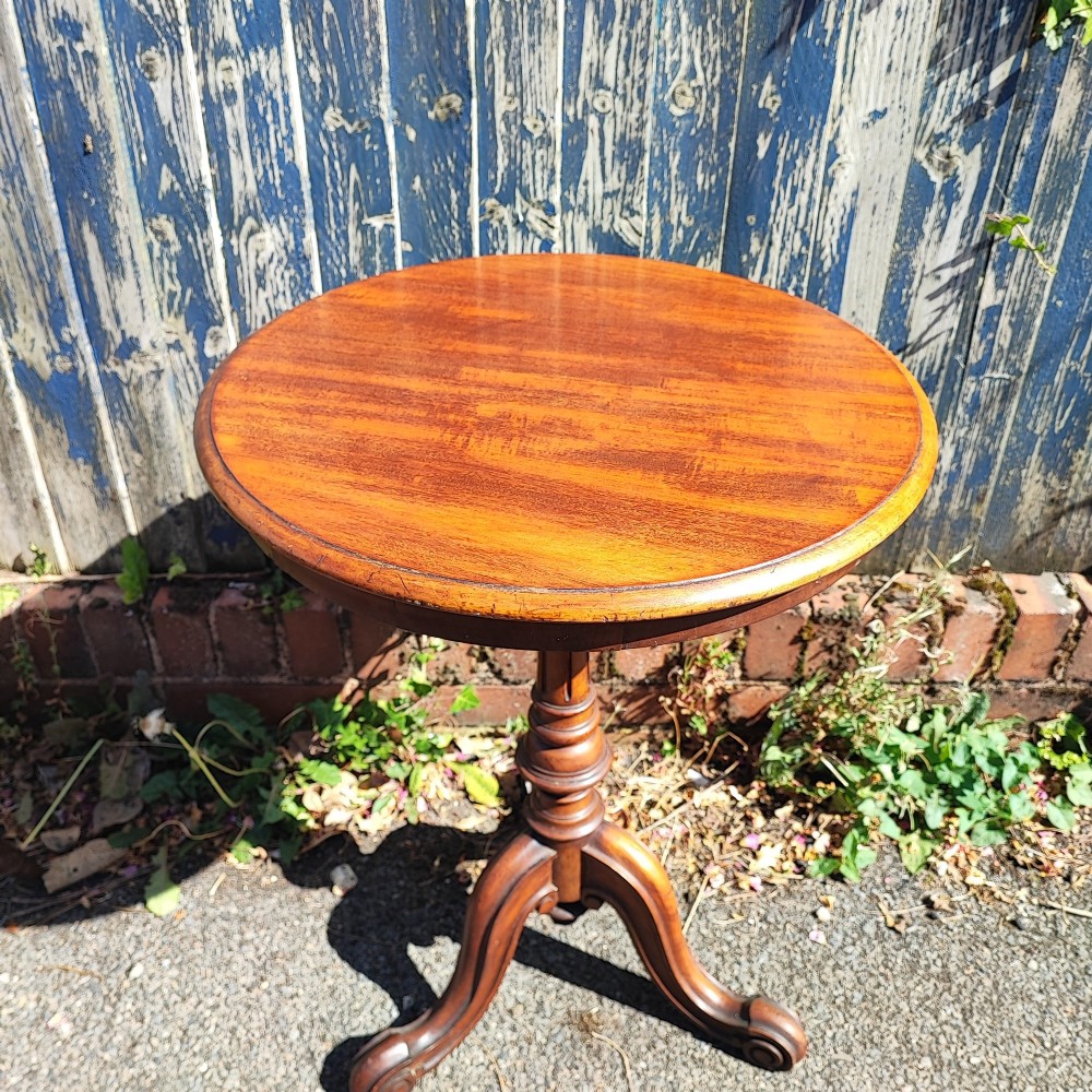 A round mahogany wine table featuring a smooth circular top, turned central pedestal column, and three carved legs ending in scroll feet. View VIII