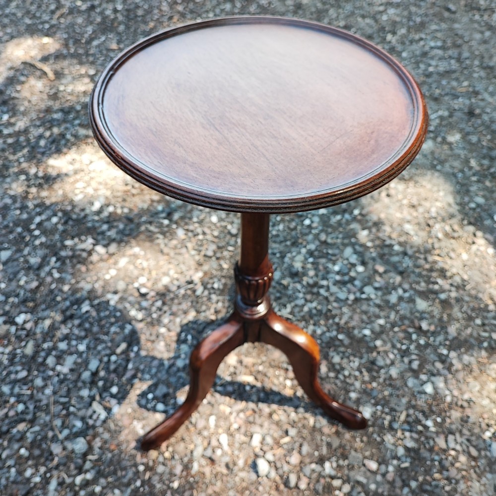 A small Edwardian mahogany wine table featuring a circular dished top supported by a turned stem and tripod legs.