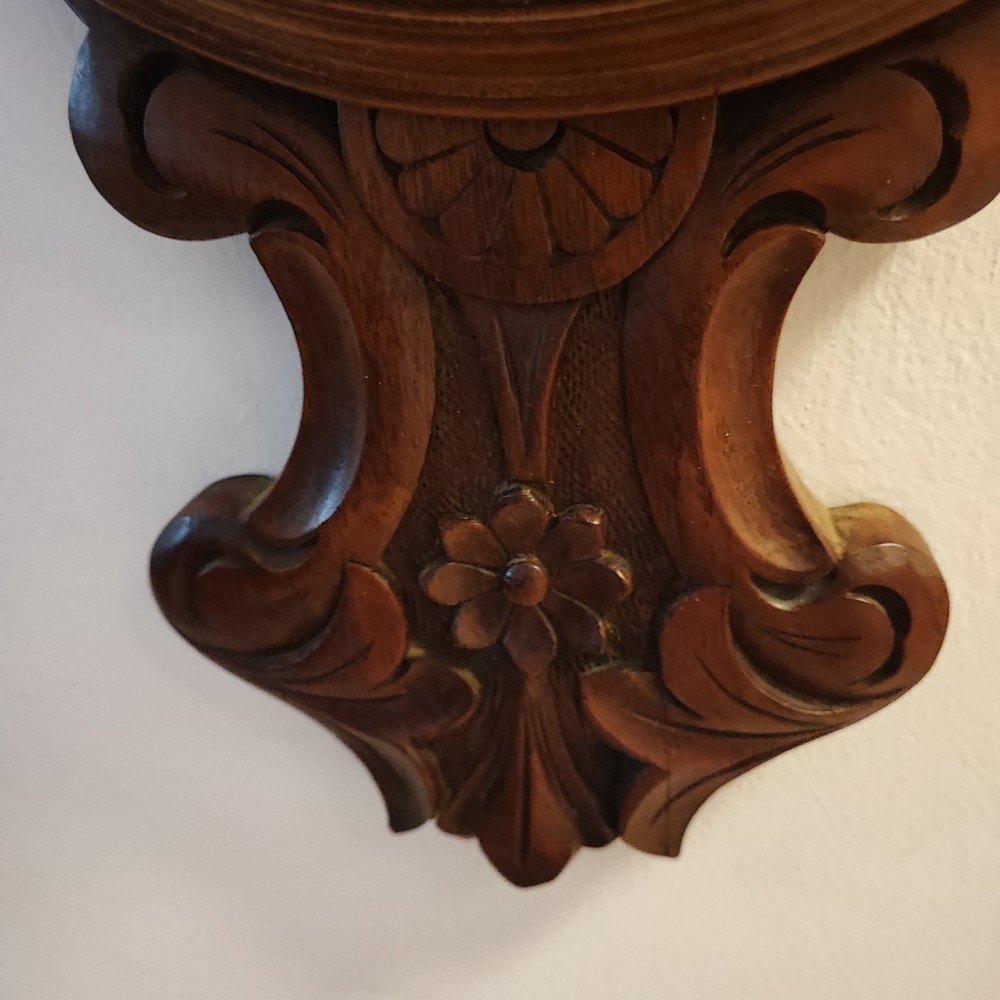 A carved Victorian mahogany aneroid wall barometer featuring top scrollwork, an integrated thermometer trunk, and a circular brass-rimmed dial. View III