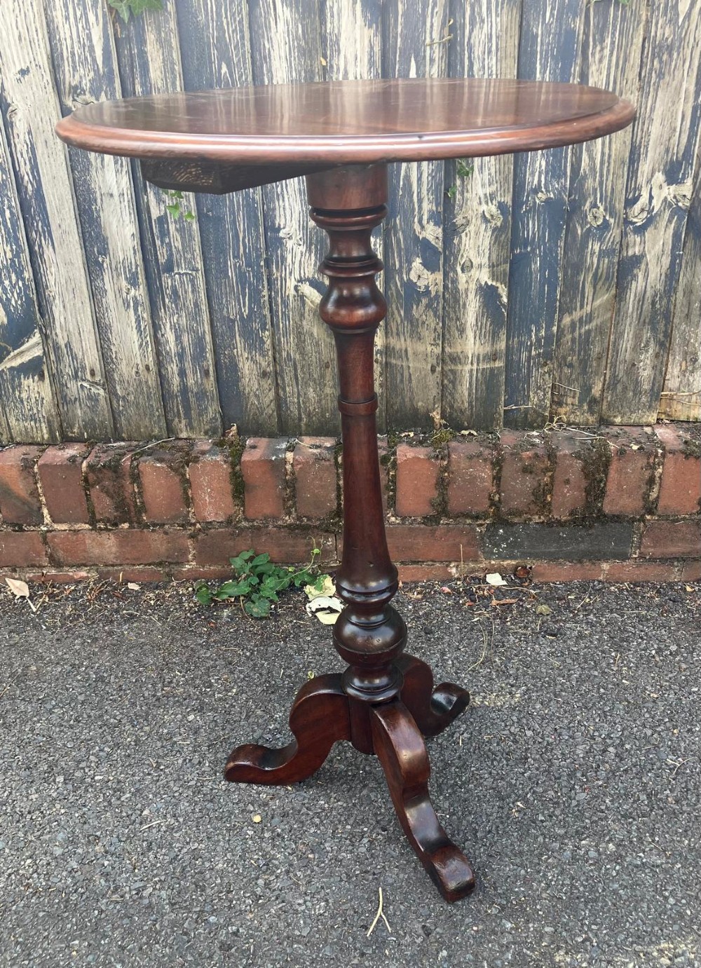A circular mahogany wine table featuring a turned central column and a tripod base. View III