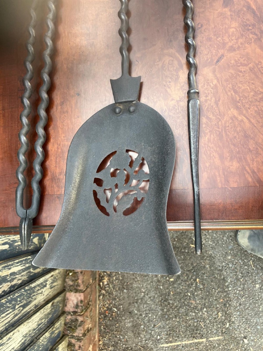 A set of three Regency fire irons featuring a poker, pierced shovel, and tongs with twisted steel shafts and cast brass handles. View III