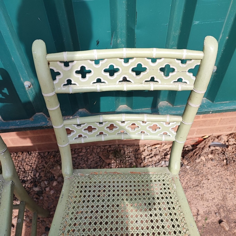 A pair of pale green painted side chairs featuring faux bamboo turned wooden frames, latticework backrests, and woven cane seats. View II