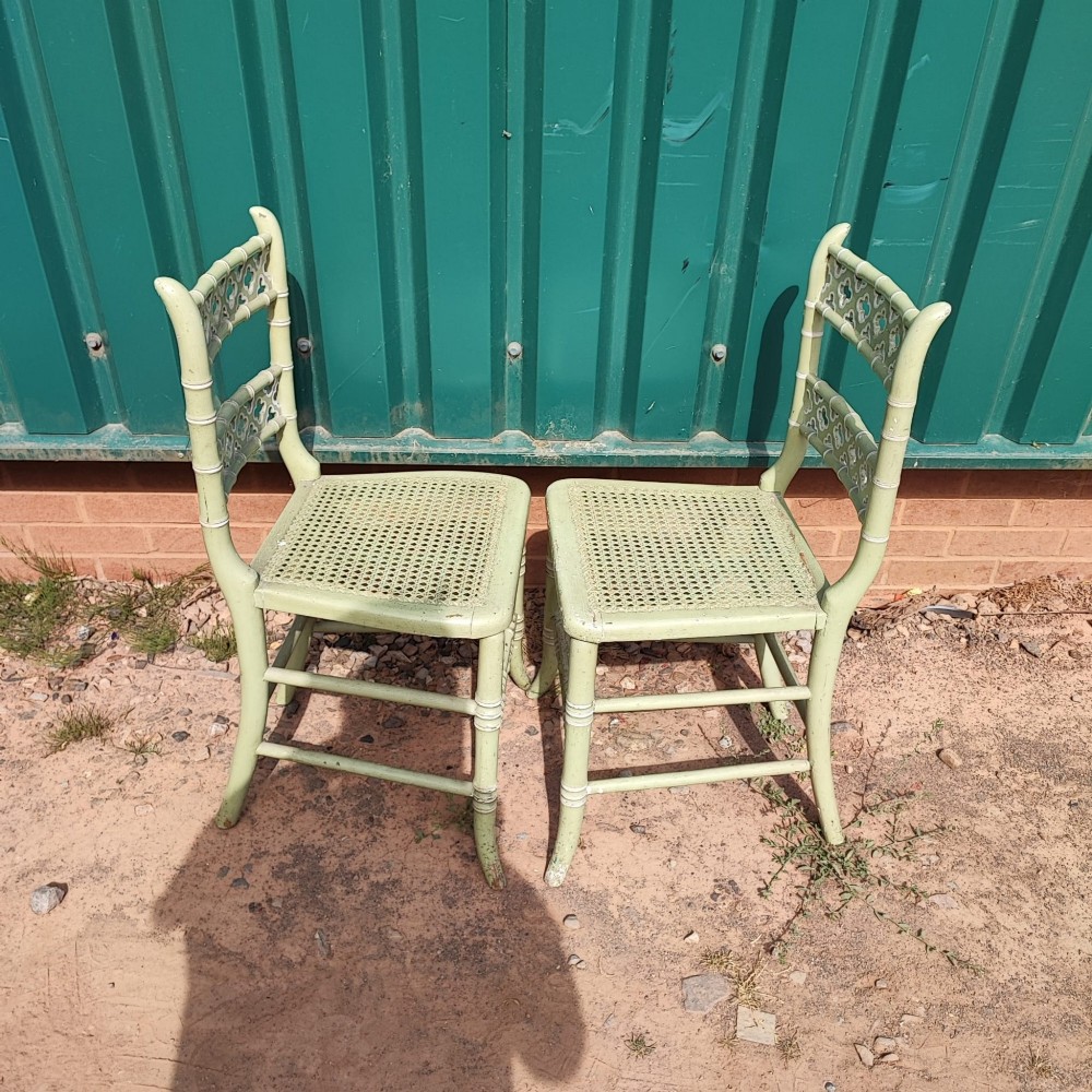 A pair of pale green painted side chairs featuring faux bamboo turned wooden frames, latticework backrests, and woven cane seats. View III