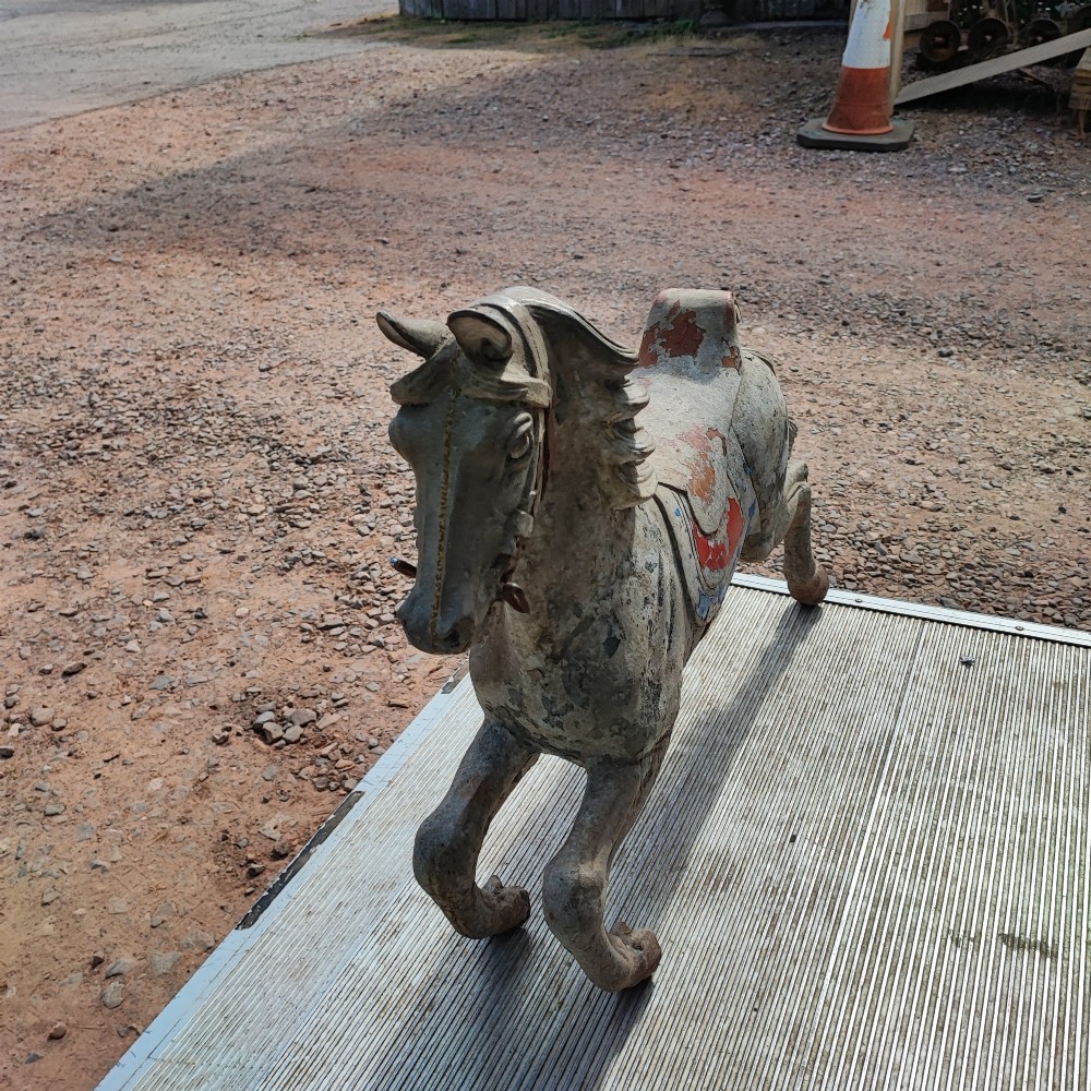 A cast metal antique carousel horse displaying distressed blue, red, and white paint with a weathered surface patina. View III