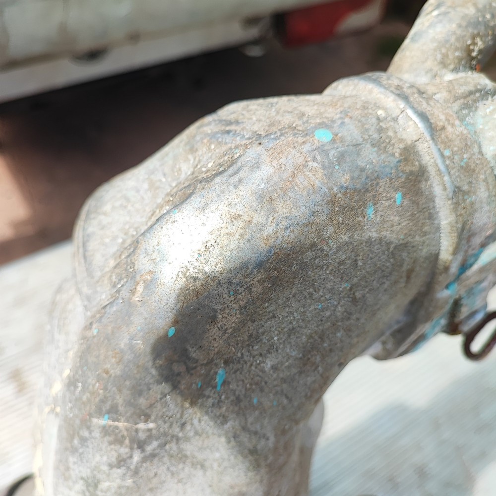 A cast metal antique carousel horse displaying distressed blue, red, and white paint with a weathered surface patina. View IV
