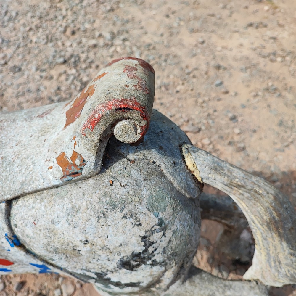 A cast metal antique carousel horse displaying distressed blue, red, and white paint with a weathered surface patina. View V