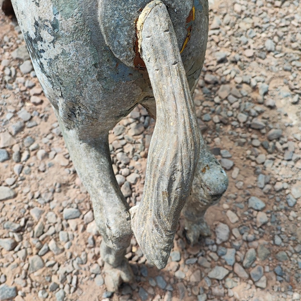 A cast metal antique carousel horse displaying distressed blue, red, and white paint with a weathered surface patina. View VII