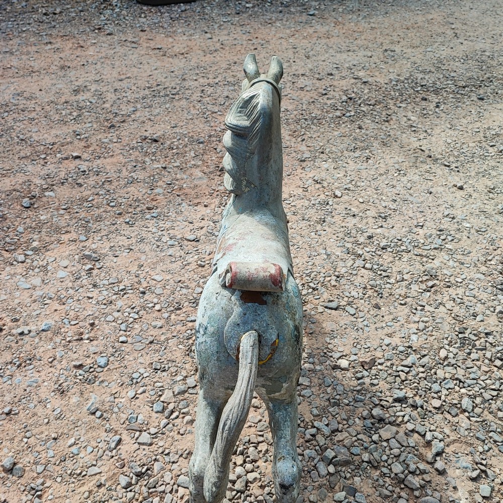 A cast metal antique carousel horse displaying distressed blue, red, and white paint with a weathered surface patina. View VIII