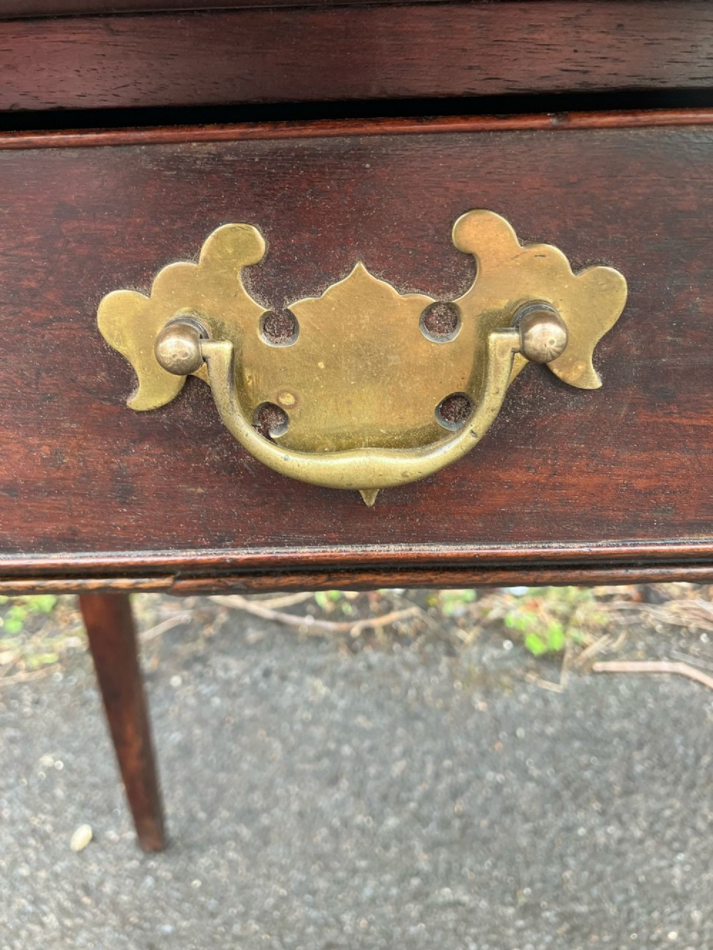A Georgian bow-fronted mahogany side table featuring a single drawer with two brass handles and supported on four square tapered legs. View III
