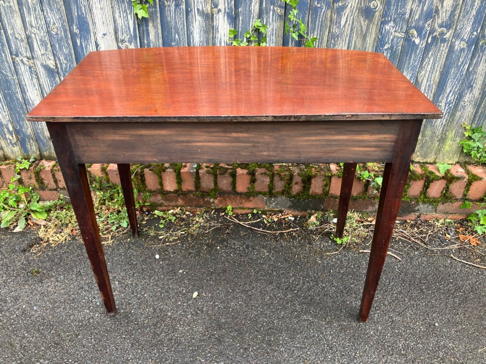 A Georgian bow-fronted mahogany side table featuring a single drawer with two brass handles and supported on four square tapered legs. View VI