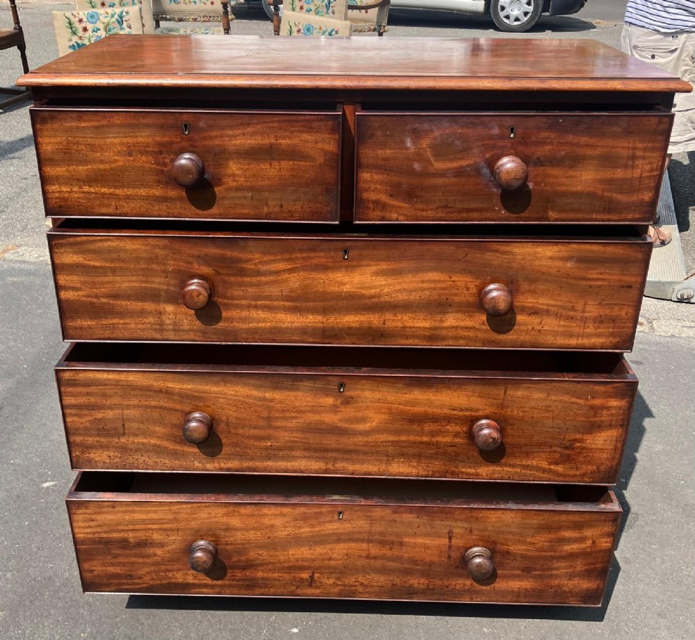 A Victorian flame mahogany chest of drawers featuring a two-over-three drawer configuration, turned wooden knobs, and a solid plinth base. View II
