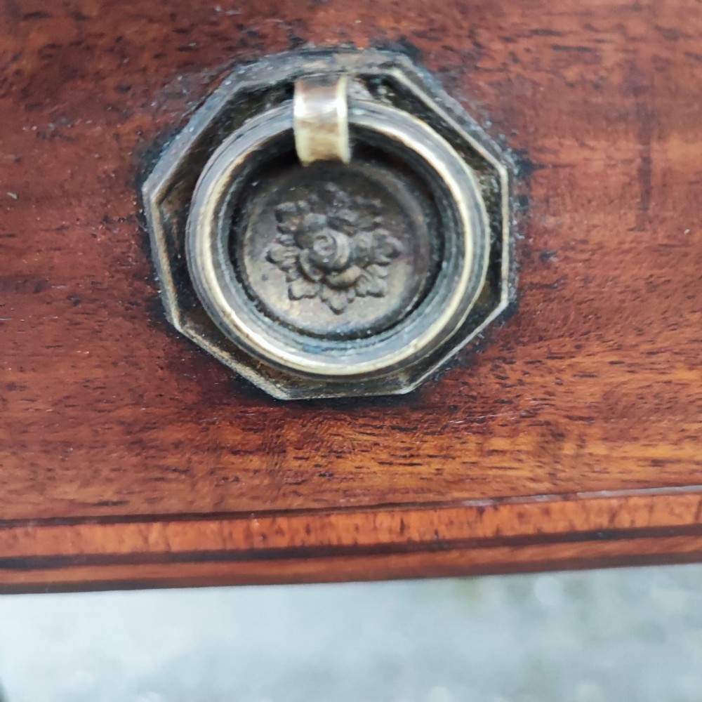 A Georgian mahogany Pembroke table featuring two hinged drop leaves, a central frieze drawer with brass ring handles, boxwood stringing, and tapered legs on brass castors. View V