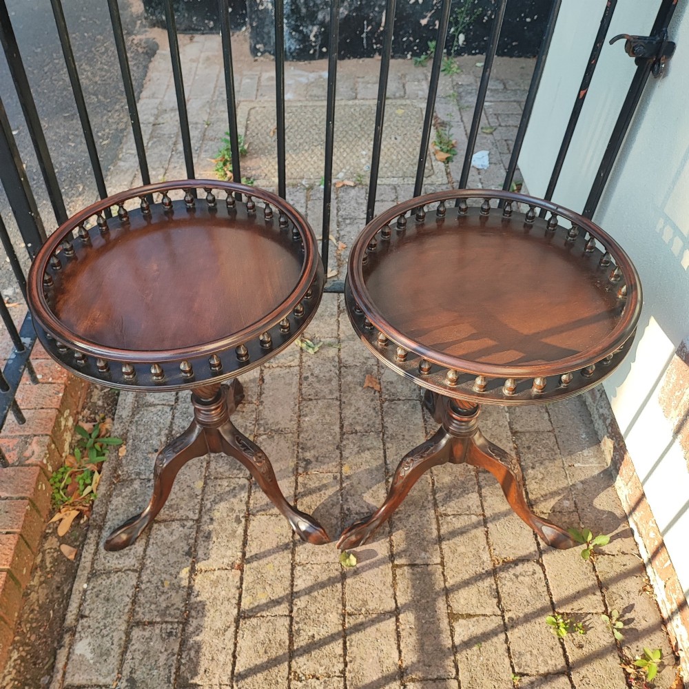 A pair of dark mahogany tripod tables featuring circular tops with spindle galleries, turned shafts, and carved cabriole legs with claw and ball feet. View III