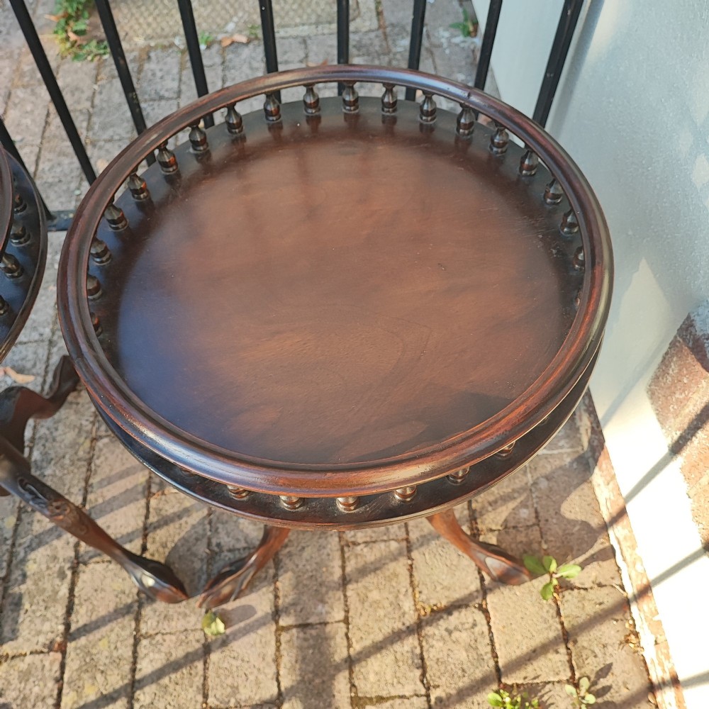 A pair of dark mahogany tripod tables featuring circular tops with spindle galleries, turned shafts, and carved cabriole legs with claw and ball feet. View IV